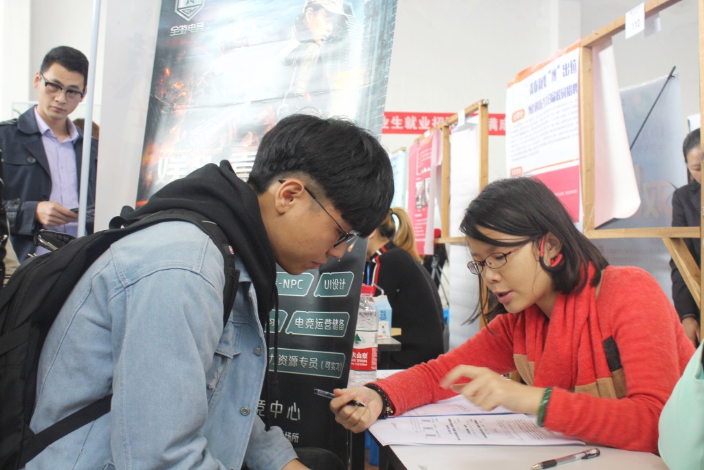 招聘单位工作人员认真聆听求职者的询问,并耐心解答